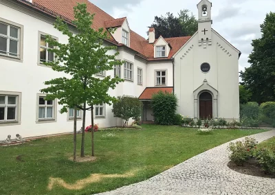 Bischhofshaus. Teil einer kleinen Kapelle und ein kleiner garten davor.